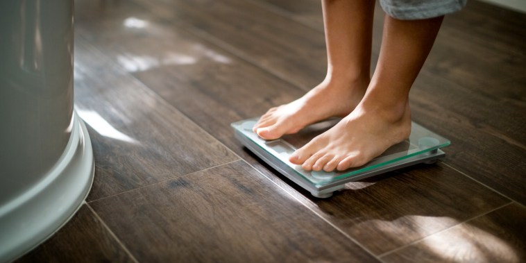 Image: Boy checking his weight on weight scale