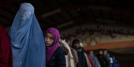 Image: Woman and child queue to receive cash at a money distribution site organized by the World Food Program in Kabul, Afghanistan, on Nov. 20, 2021.