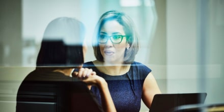 Businesswoman in discussion with client in office conference room