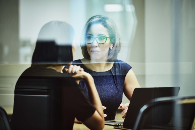 Businesswoman in discussion with client in office conference room